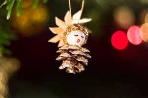Kleiner singender Weihnachtsengel aus einem Tannenzapfen als Gutschein für Gesangsunterricht in Koeln.